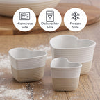 Heart-shaped ceramic bowls on a wooden surface with safety icons indicating microwave, dishwasher, and freezer safety.