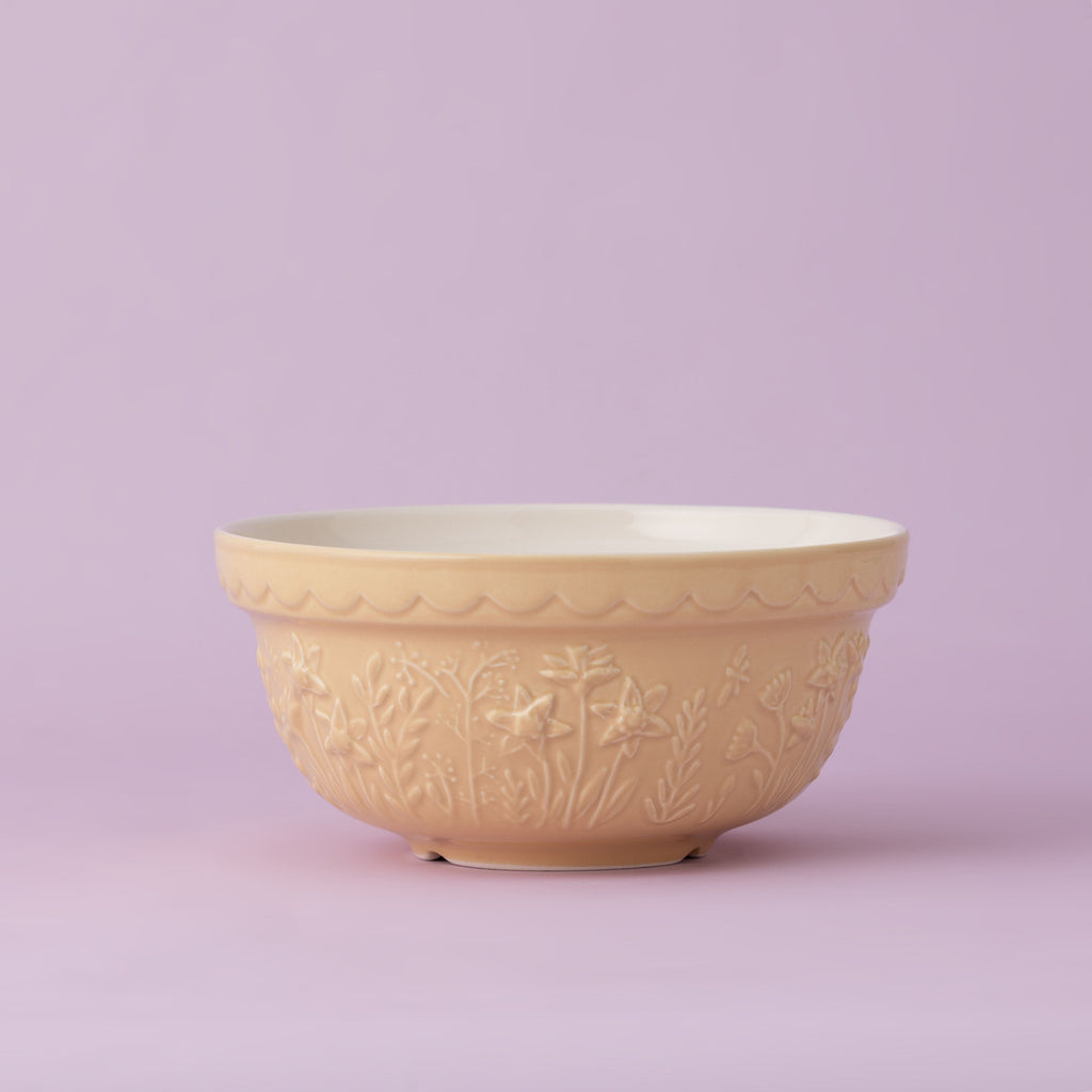 Yellow ceramic bowl with floral patterns on a light purple background