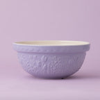 Purple mixing bowl with floral patterns on a light purple background