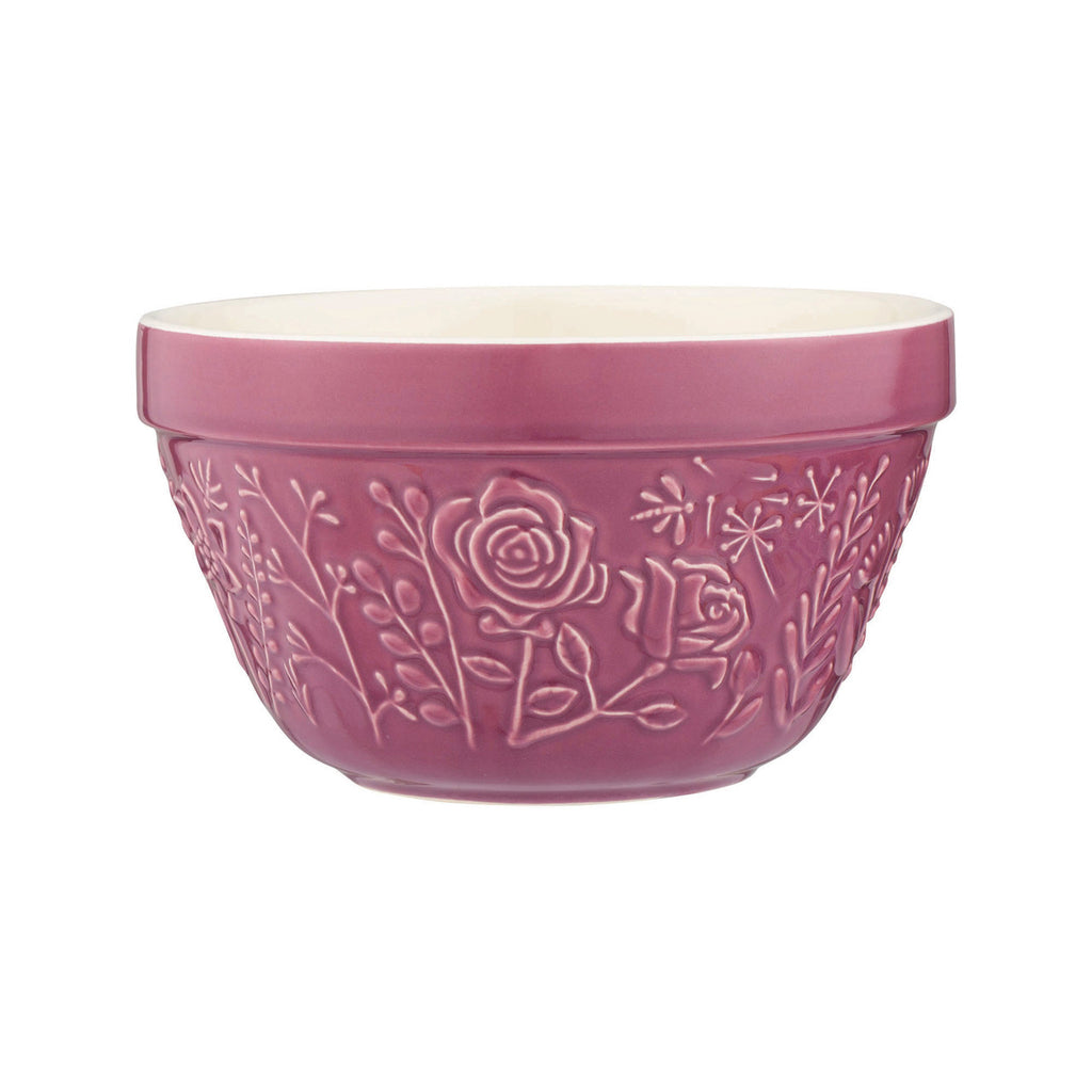 Pink ceramic bowl with floral embossing on a white background