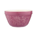 Pink ceramic bowl with floral embossing on a white background