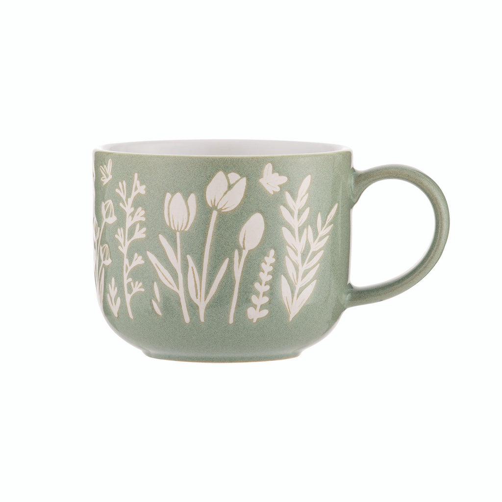 Green mug with white floral patterns on a white background