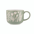 Green mug with white floral patterns on a white background