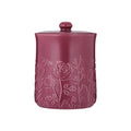 Pink ceramic jar with floral embossing on a white background