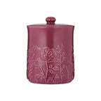 Pink ceramic jar with floral embossing on a white background