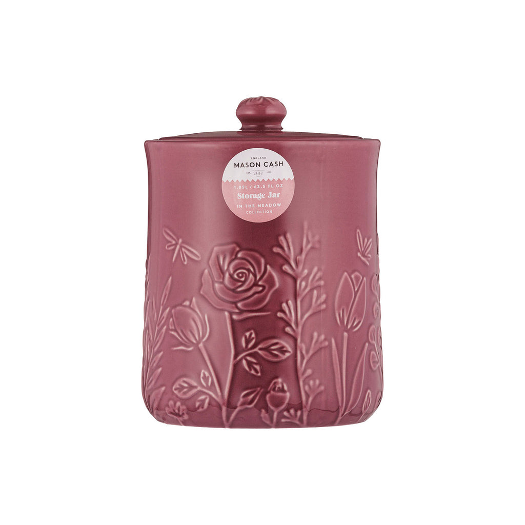 Pink storage jar with floral embossing on a white background