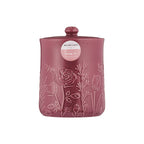 Pink storage jar with floral embossing on a white background