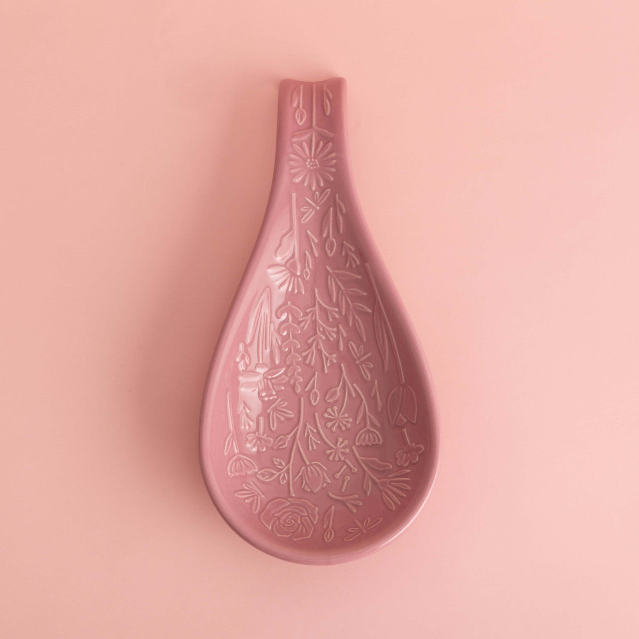 Pink ceramic vase with floral patterns on a pink background