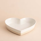Heart-shaped white ceramic bowl on a beige background