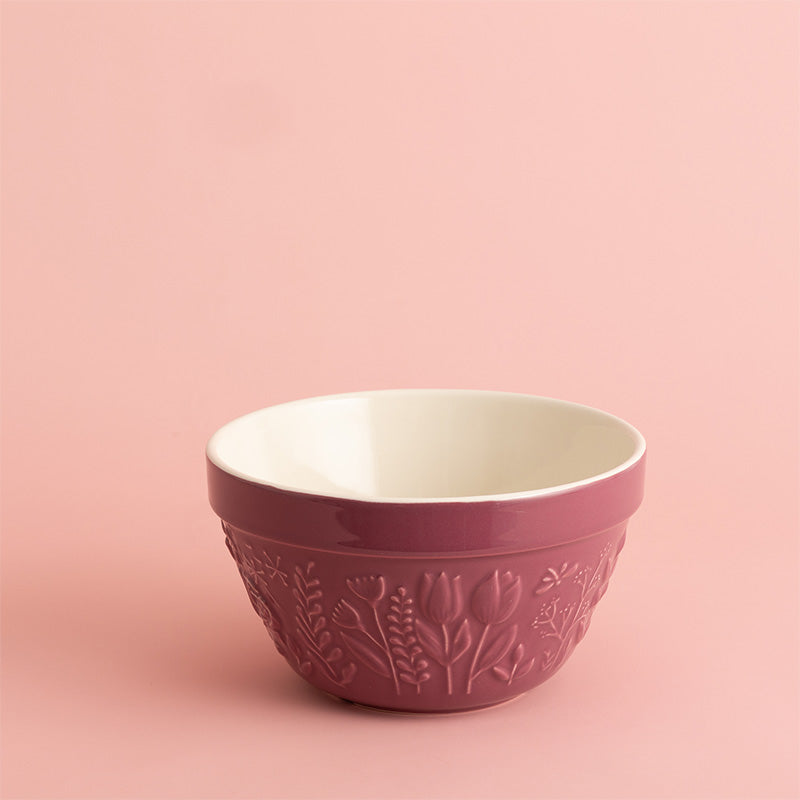 Pink ceramic bowl with floral patterns on a pink background